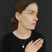 Femme portant l’ensemble Excellence Perle doré : bague, boucles d’oreilles et collier au lait maternel